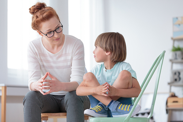 child speaking with therapist