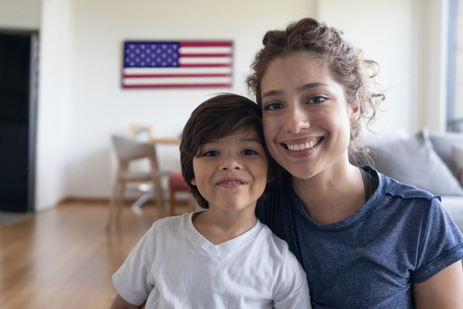 mother and child smiling with flag in background